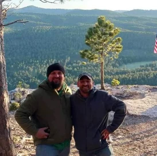 Two men in hoodies camping